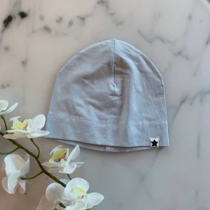 Ny mössa ljusblå storlek  62-68 - Ny oanvänd mössa ljusblå. Inga lappar kvar då den var del av ett 3-pack. Strl 62/68 