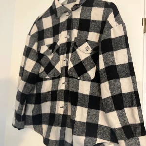 Flanell Jacka - Svart/vit rutig flanell jacka i storlek  S, dock är själva modellen oversize. I fint men använt skick