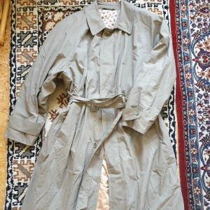 Unik kappa  - Unik retro kappa! Trenchcoat form och detaljer. Mycket söt insida. Fodrad som en tunn dunjacka.  Ej märkbart använd, väldigt fint skick. För stor för mig.  Skriv DM för fler bilder och mått!