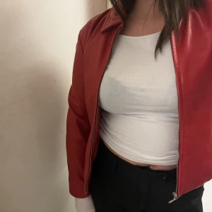 Röd läderjacka - Supersnygg vintage röd läderjacka (äkta läder). Jättemjuk och i toppskick! Strl: S, rak modell. Har en innerficka som försluts med dragkedja. 