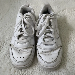 Nike court borough low 2 gs - Ett par vita Nike skor i strl 37,5.                                              Lagom använda därav säljer jag skorna för 49kr!💛                                                                    