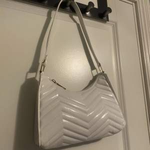 Säljer denna vita handväska, bandet är ej justerbart, väskan har inga inne fack, säljer den då den ej kommer till användning länge. 