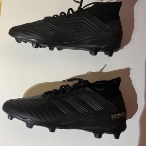 Använda Adidas Fotbollsskor Size 42 - Använda Svarta Adidas Preditor Fotbollsskor. Storlek 42 Och lite slitna men inga hål eller större skador, annars väldigt bra skor 