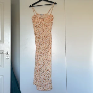 Småblommig sommarklänning  - Lång figurnära sommarklänning från stradivarius, justerbara band, formade kupor med slits där bak. Aldrig använd och med lappen kvar, väldigt liten i storleken med stretchigt material 