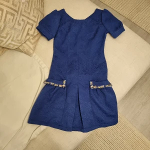 Klänning  - Klänningen är ny skick och kvalitet. Bara En gån använd. Varumärken är Sogo. Det finns inte i Sverige denna brand. Färgen är blå och det finns pearl detaljer på kläningen.