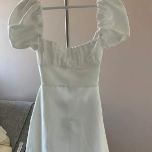 Vit klänning med knyte i ryggen från Zara i storlek XS. Oanvänd och har lappen kvar.