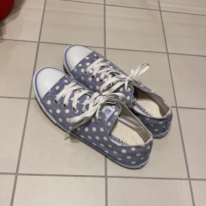 Converse - Ett par blåa converse med vita prickar 