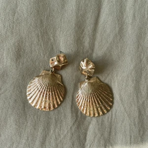 Snäckskalsörhängen - Super cute örhängen formade som snäckskal. Ej äkta guld, kan en garantera nickelfritt. Oanvända men olika pluppar eftersom jag fått nödnorpa en 😂