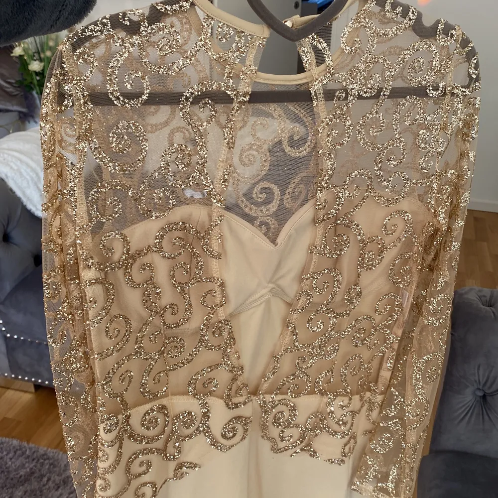 En super fin klänning från Dennis Marglic i guld med guld glitter. Klänningen är lite längre och är öppen i ryggen. . Klänningar.