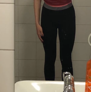 Svarta träningstights - Helt vanliga träningsbyxor med tight passform och rosa&grått band.