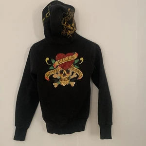 ED HARDY HOODIE - SÅ SNYGG!! Älskar denna men kommer tyvärr ej till användning längre😩 Det finns många stenar kvar på den men även många som är borta men ej något man tänker på!! BUDA PRIVAT!! BUDA EJ UNDER 300kr Köp direkt för 60kr! HÖGSTA BUD: 630kr