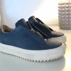 Sneakers - Axel Arigato  - Skitsnygga skor från Axel Arigato. Storlek 38. Har vissa slitningar (se sista bilden) men är annars fräscha. Nypris 1900kr. 🛑får många frågor ifall de är fejk eftersom man inte ser någon logga på bilderna. Det står ”Arigato” väldigt diskret på sidan av skon. De är även köpta år 2017 och är därför en äldre kollektion🛑