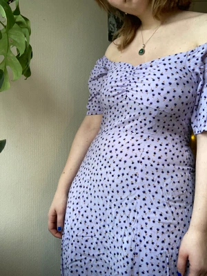 Blommig sommarklänning - Supergullig lila, blommmig sommarklänning. Axlarna går att ha som man vill. 