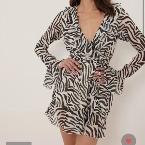 Na-kd klänning - Klänning med zebramönster och volanger från NA-KD, aldrig använd med lappen kvar. Nypris 389kr.
