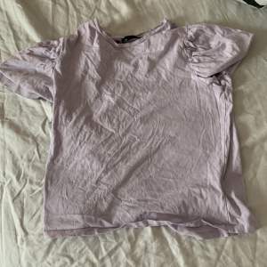 En lila t-shirt med puffärmar 