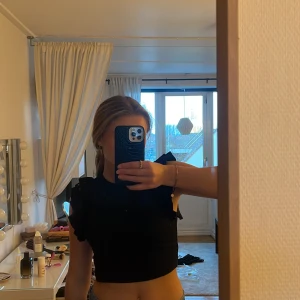 Svart volangtopp från Zara - Säljer denna söta volangtopp från Zara för den inte kommit till användning. Använd 1 gång, som nyskick. Går ej att köpa längre, skriv för fler bilder.
