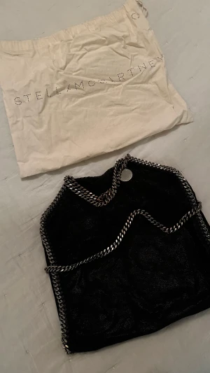 Stella McCartney väska - Stella McCartney Falabella bag, svart. Fint skick i övrigt. Inga märken på utsuddad eller insidan. Lite nött på handtag längst upp.   Nypris: 9800 https://www.mytheresa.com/euro_en/stella-mccartney-falabella-mini-shoulder-bag-604174.html?rrec=true