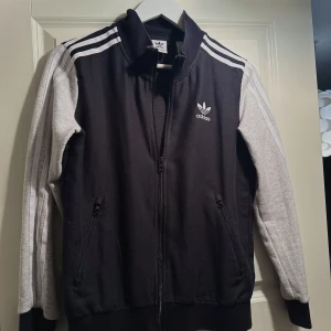 Adidas kofta - Adidas kofta i grå och svart. Storlek xs/s