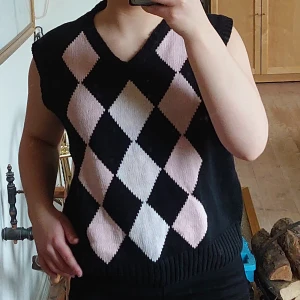 Svart och rutig väst  - Svart väst med rosa och vita romber från CRW. Är i bra skick, inget slitage. 