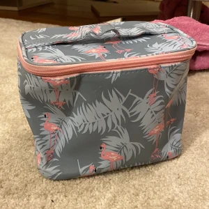  en stor Necessär med flamingos på -  En stor grå necessär med flamingos på