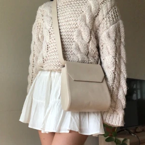 COS axelväska - Unik beige axelväska i skinn från COS i beige/greige färg. Minimalistisk design, remmen är justerbar. Ganska rymlig och praktisk!