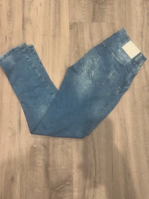 Replay jeans - Snygga blå slim fit jeans med en tvättad och något blekt look. Jeansen har klassisk femficksdesign och raka ben. Perfekta för en avslappnad och trendig stil.
