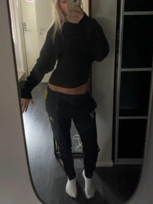 Svart tröja/topp - Säljer en svart topp från Nelly där tröjan är ribbad genomskinlig men syns ej när den sitter på kroppen. Man han ha den både men en arm nedanför axel eller rak. Fint skick har använt kanske 5 ggr