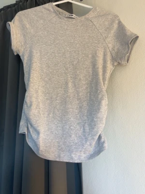 Grå T-shirt  - En grå tröja från newyorker med lite ”insvängning” i midjan