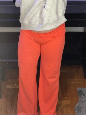 Koralröda yogabyxor med vida ben - Säljer ett par koralröda mjukisbyxor med skön passform och vida ben. Byxorna har elastisk midja och är gjorda i mjukt material som känns bekvämt. Perfekta för dagar när du vill ha något avslappnat men ändå snyggt❣️De byxorna som jag har på mig är i storlek S, men de som jag säljer, som syns på golvet, är i storlek M( jag köpte en storlek mindre av samma byxor som jag inte säljer, men de är precis samma modell)!❣️Har som sagt bara tagit av prislappen och testat dem en gång❣️