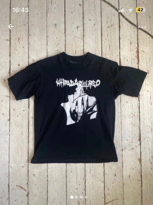 Playboicarti T shirt - Säljer en svart t-shirt med grafiskt vitt tryck både fram och bak. T-shirten har korta ärmar och en normal passform. Perfekt för dig som gillar bandmerch och streetwear vibes.