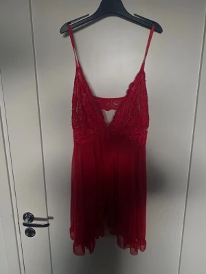 Rött spetsigt underklädesset - Säljer ett rött underklädesset med spetsdetaljer. Setet består av en babydoll med tunna axelband och djup urringning samt en matchande lång, transparent kimono med spetskant. Materialet är tunt och genomskinligt, vilket ger en romantisk och elegant känsla. Olika Storlekar Stringen är i xxl och den långa med band till är en M nattlinnet stod det ingen storlek men den är stretchig och gissar på en M eller xl. Allt är helt oanvänt. Har dock inte kvar originalförpacknkningar. Därav priset.