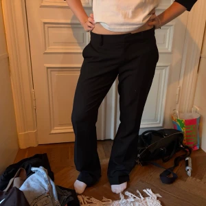 Svarta raka kostymbyxor - Snygga svarta kostymbyxor med rak passform och normal/låg midja. Byxorna har sidofickor och klassisk look som passar till många olika tillfällen. Använda 1-2 gånger