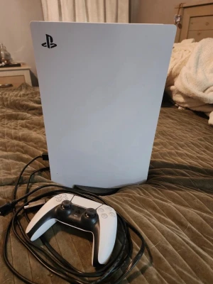  PlayStation PS5 Slim 1TB White Console Disk Edition - PlayStation 5 konsol i vit och svart med tillhörande DualSense-handkontroll. Konsolen har en futuristisk design med släta, böjda paneler och mattsvarta detaljer. Medföljer gör även ett paket med joystick-tillbehör för handkontrollen. Vid köp med swish - bättre rabatt