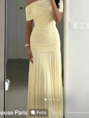 Ljusgul offshoulder långklänning - Otroligt fin klänning från Gracieuse ✨ En vacker och elegant klänning i en underbar butter yellow färg. Klänningen är endast använd en gång och är i väldigt fint skick. Tyget är tunt och luftigt med flera lager som ger klänningen ett fint fall.  Perfekt för både fest, bröllop, student eller andra speciella tillfällen. 💛 Villig att gå ner i pris orginalpriset är 900kr