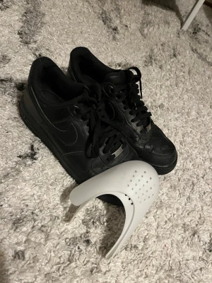 Svarta Nike airforce 1 - Säljer mina svarta Airforce 1’s, svarta o knappt använda men suttit i en låda så det är crease på dem men super lätt och få bort, erbjuder crease skydd som tar bort det, hade det på mina Vita och crease försvann relativt bra, inget synligt på dom nåmer!   Kan gå ner i pris! Vid snabb köp!