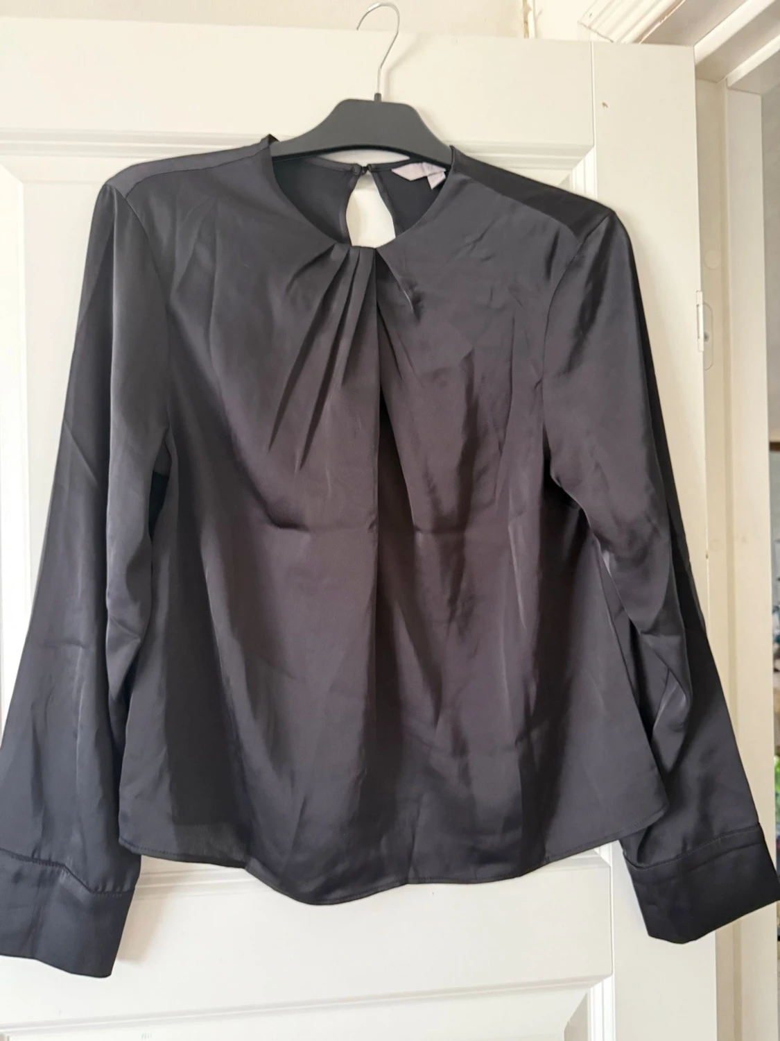 Svart blus med veckad detalj - 1
