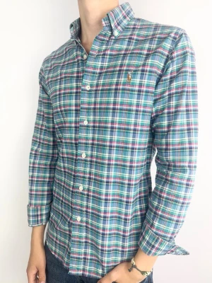 Ralph Lauren skjorta rutig - Ralph Lauren Skjorta Märke: Polo Ralph Lauren Storlek: M Passform: Slimfit Färg: Rosalila mönstrad Skick: Mycket bra Beskrivning: utan defekter. Modellen på bilden: 183 cm / 72 kg