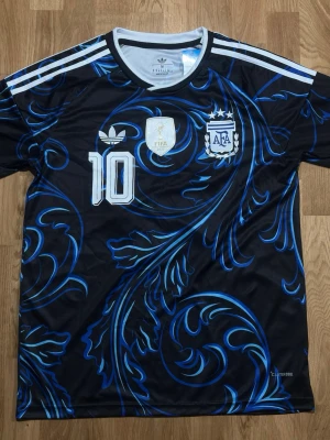 Argentina Away Jersey 2026 World Cup Messi #10 – Size M - Own a piece of football history with this iconic Argentina 2026 Away Jersey featuring the legendary Lionel Messi #10  * 🇦🇷 Argentina 2026 Away Jersey * ⭐ Lionel Messi #10 * 📏 Size: Medium (M) * ✅ Premium quality * 💨 Lightweight & breathable material * 👕 Comfortable athletic fit * ⚽ Perfect for fans, collectors, and casual wear  A timeless Messi jersey that belongs in every football collection. Secure yours before it’s gone!