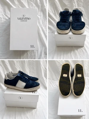 Valentino Garavani blåa sneakers - Snygga sneakers från Valentino Garavani i marinblå mocka och vitt läder. Klassisk låg modell med vita detaljer och mörkblå snören. Yttersulan är vit med mönstrad undersida. Perfekta för dig som vill ha en stilren och exklusiv look. Det saknas några nitar på baksidan och dem är lite slitna overall men änåd bra skick.