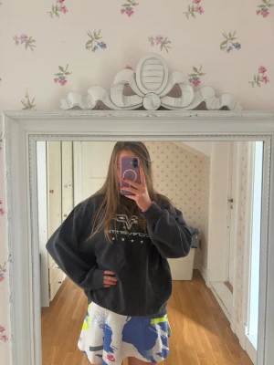 Svart oversized sweatshirt med tryck - Cool svart oversized sweatshirt med vitt tryck framtill och stjärndetaljer. Tröjan har en avslappnad passform och långa ärmar, perfekt för en casual och trendig look. Passar dig som gillar streetwear och vill ha något bekvämt och stilrent.
