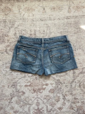 Vintage Lågmidjade jeansshorts / vintage low waisted shorts  - Superfina vintage shorts med slitningar och låg midja!  Midjemått: 37cm  Längd: 26cm
