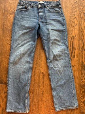 Blå raka jeans  - Ett par klassiska blå jeans med rak passform från Gina. Dessa byxor har blivit lite slitna längst ner i benen! 