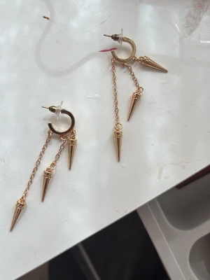 Guldiga örhängen med kedjor och spikes - Guldiga örhängen oanvända 