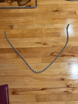 Silverfärgat tvinnat halsband - Snyggt halsband i silverfärg med tvinnad kedja som ger en cool och stilren look. Perfekt att bära som det är eller att kombinera med andra smycken för en personlig stil. Halsbandet har ett klassiskt lås och passar till många olika outfits.