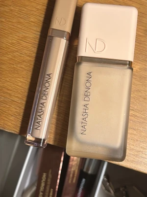 Natasha Denona Foundation/ concealer N3 - Foundation från Natasha Denona i nyansen N3. Kommer i en stilren glasflaska med matt beige lock och matchande concealer i samma nyans. Båda produkterna har en modern, minimalistisk design och ger en naturlig finish. 