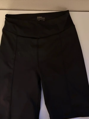 Svarta cykelshorts från Lefties - Säljer ett par svarta cykelshorts från Lefties, perfekta för träning eller vardagsaktiviteter. De har hög midja och är tillverkade i ett stretchigt material som ger bra rörelsefrihet. Snygg och enkel design som passar till det mesta.DM FÖR FLER BILDER 💕