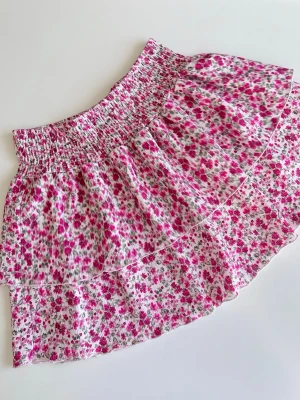 Blommig volangkjol från Gina Tricot - En rosa blommig kort kjol med volanger från Gina Tricot. Storlek M. Mycket bra skick <3