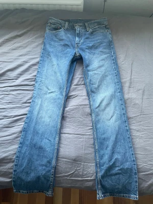 Bootcut jeans  - Säljer ett par blå 527 jeans med bootcut passform och fem fickor. Jeansen har en klassisk ljus tvätt och detaljerade sömmar på bakfickorna. Sömmen på vänstra fickan har gått upp lite, se sista bilden 