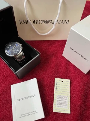 Emporio Armani blå klocka i stål - Snygg klocka från Emporio Armani med blå urtavla och silverfärgat armband i stål. Klockan har flera små urtavlor och stilrena detaljer. Perfekt accessoar för att lyfta din stil. Levereras med originalask, garantikort och manual. (Pris kan diskuteras)