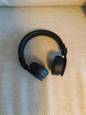 Svarta on-ear hörlurar från Iear - Snygga svarta on-ear hörlurar från Iear med justerbar bygel och mjuka öronkuddar. Hörlurarna har en stilren och minimalistisk design i plast och konstläder, perfekta för musik eller poddar på språng.